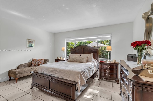 bedroom with ceiling fan, light tile patterned flooring, and a textured ceiling