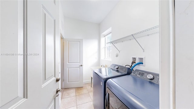 clothes washing area featuring washing machine and clothes dryer and light tile patterned flooring