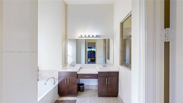 bathroom with tile patterned flooring, vanity, and a tub