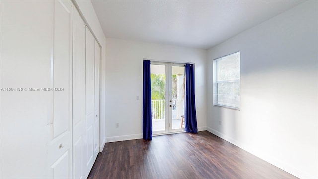 spare room featuring french doors and dark wood-type flooring