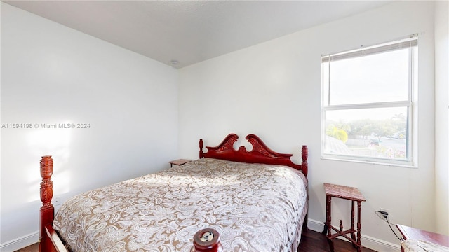 bedroom with dark hardwood / wood-style floors