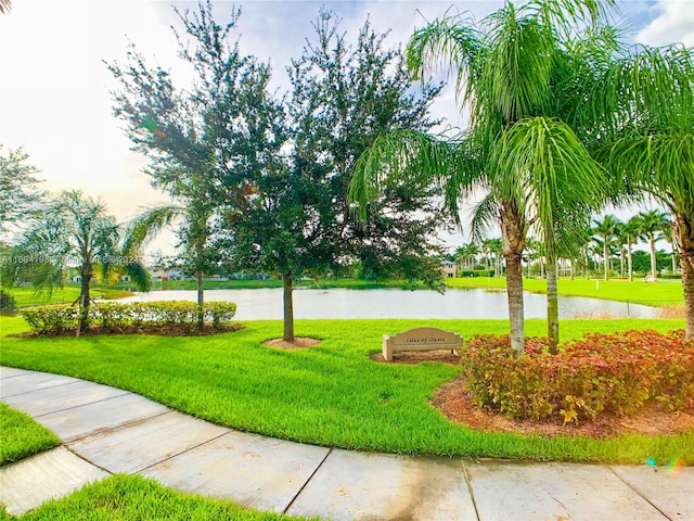 surrounding community with a lawn and a water view