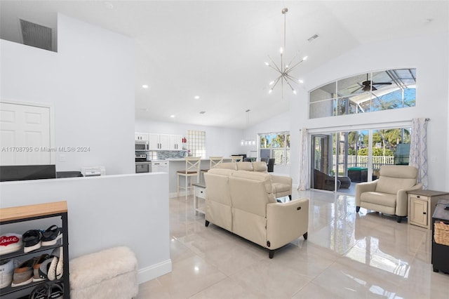 living room featuring ceiling fan with notable chandelier, light tile patterned floors, and high vaulted ceiling