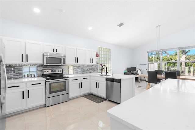 kitchen featuring stainless steel appliances, sink, decorative light fixtures, white cabinets, and lofted ceiling