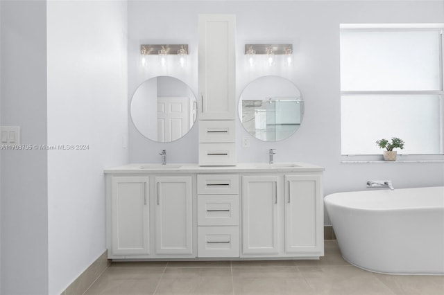 bathroom featuring tile patterned floors, vanity, and a bath