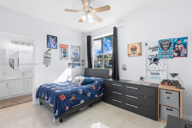 tiled bedroom featuring a textured ceiling, connected bathroom, ceiling fan, and sink