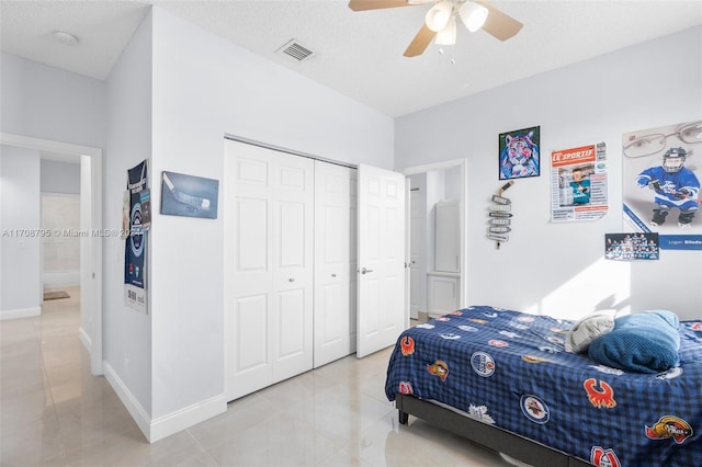 tiled bedroom featuring ceiling fan, a closet, and a textured ceiling