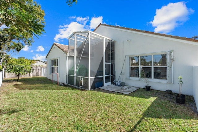 back of property with a lawn and a lanai