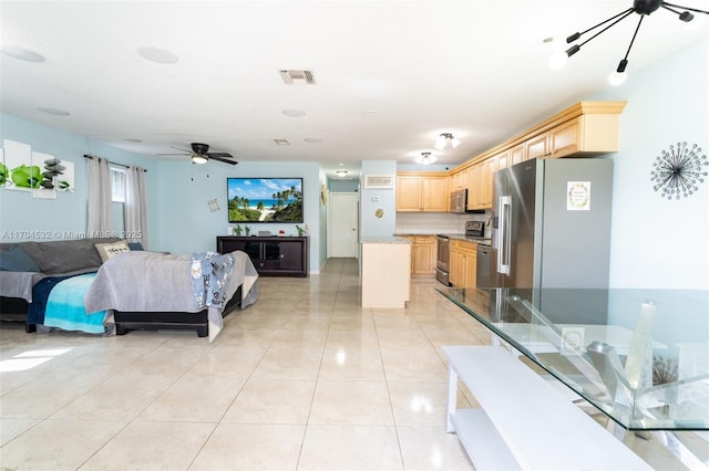 interior space with light brown cabinets, light tile patterned floors, stainless steel appliances, and tasteful backsplash