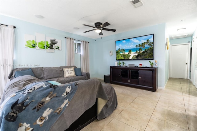 living room featuring ceiling fan, light tile patterned floors, and a textured ceiling