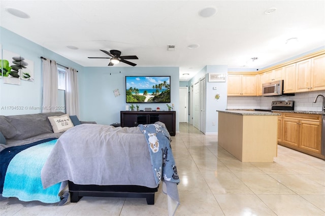 tiled living room with ceiling fan and sink