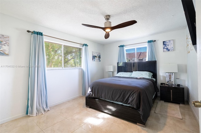 tiled bedroom featuring ceiling fan and a textured ceiling