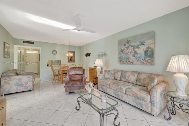 living room with light tile patterned floors and ceiling fan with notable chandelier