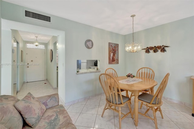 dining space with light tile patterned floors and an inviting chandelier