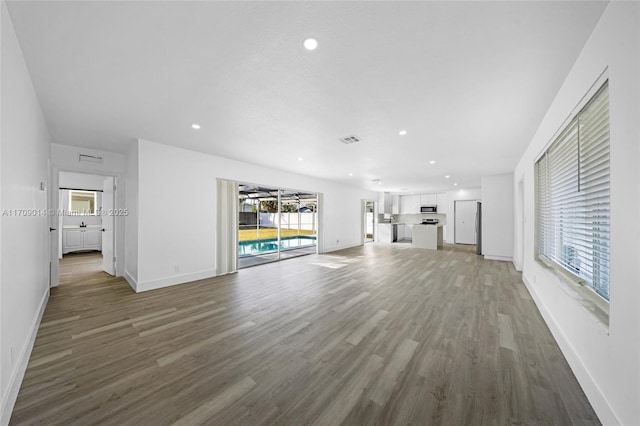 unfurnished living room with hardwood / wood-style floors and a healthy amount of sunlight