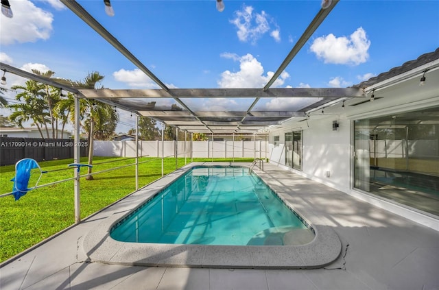 view of pool with a lawn, glass enclosure, and a patio