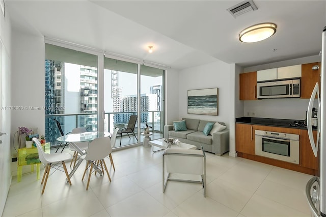 tiled living room featuring a wealth of natural light and a wall of windows