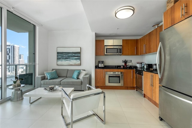 300 S Biscayne Blvd Unit T-2309, Miami, FL 33131 - kitchen with stainless steel appliances, brown cabinets, dark countertops, a wall of windows, and open floor plan