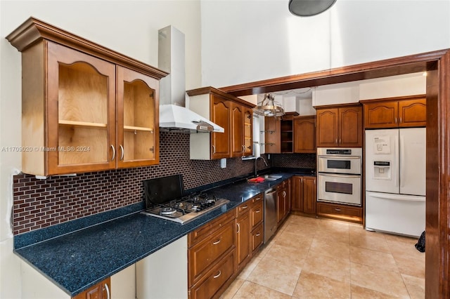 kitchen with backsplash, wall chimney range hood, sink, light tile patterned floors, and appliances with stainless steel finishes