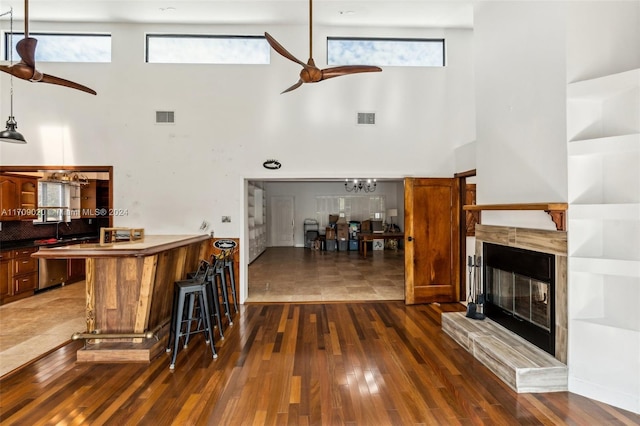 living room featuring ceiling fan, dark wood-type flooring, and a high ceiling