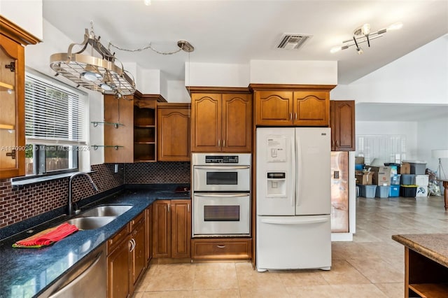 kitchen featuring backsplash, light tile patterned floors, sink, and appliances with stainless steel finishes