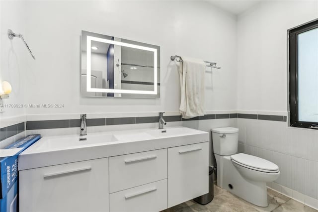 bathroom with walk in shower, vanity, tile walls, tile patterned flooring, and toilet