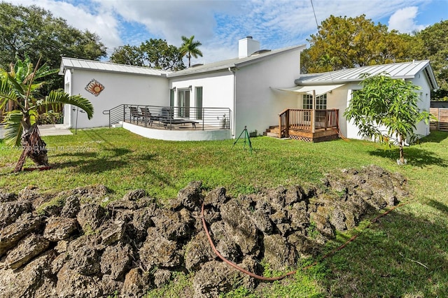 back of house featuring a wooden deck and a yard