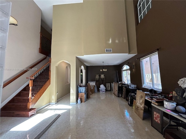 entrance foyer with a notable chandelier and a towering ceiling