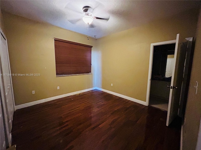 unfurnished bedroom featuring dark wood-style floors, a ceiling fan, and baseboards