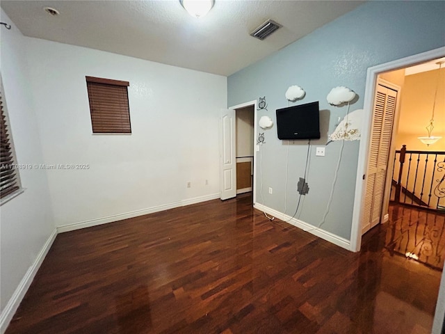 unfurnished bedroom featuring visible vents, baseboards, and wood finished floors