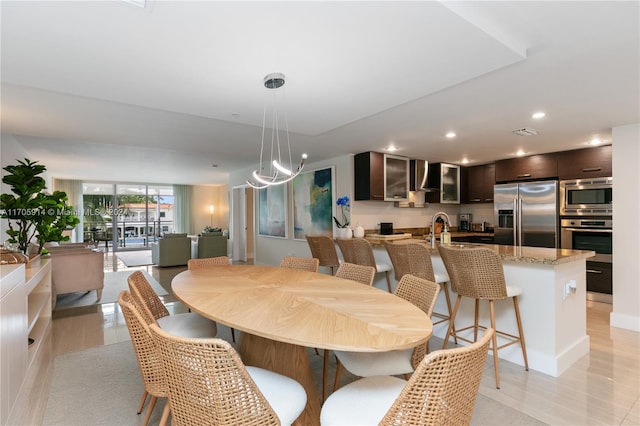 dining area with expansive windows, light tile patterned floors, and sink