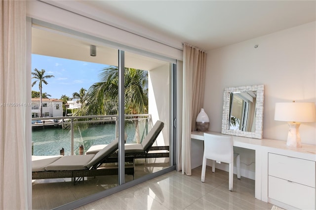 entryway with built in desk, a water view, and a wealth of natural light