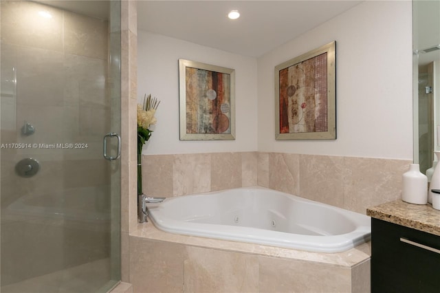 bathroom featuring vanity and independent shower and bath