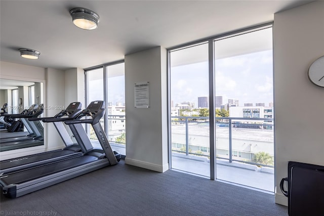 workout area with expansive windows, dark carpet, and plenty of natural light