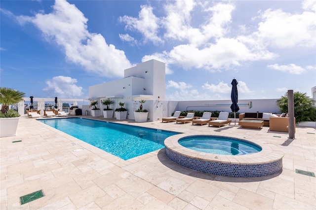 view of pool featuring a patio area and an in ground hot tub