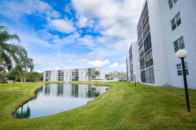 surrounding community with a lawn and a water view