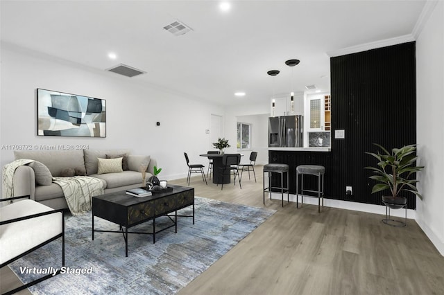 living room with light hardwood / wood-style flooring and ornamental molding