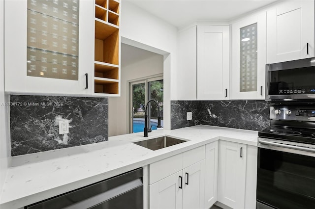 kitchen featuring backsplash, sink, white cabinets, and appliances with stainless steel finishes