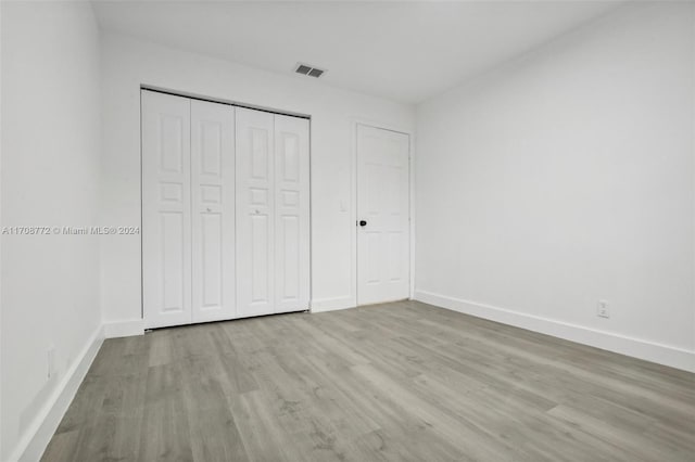 unfurnished bedroom with light hardwood / wood-style floors and a closet