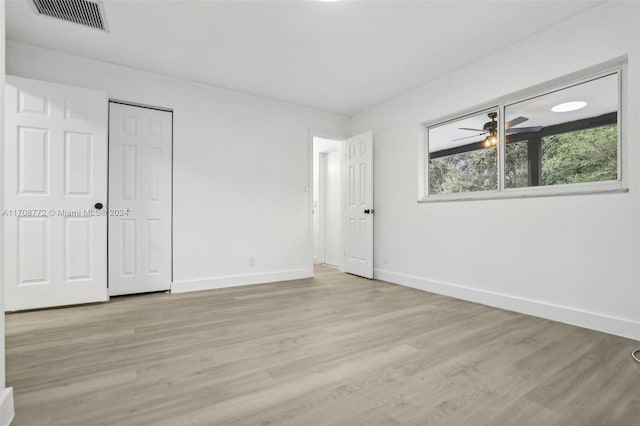 unfurnished bedroom with light hardwood / wood-style flooring and a closet