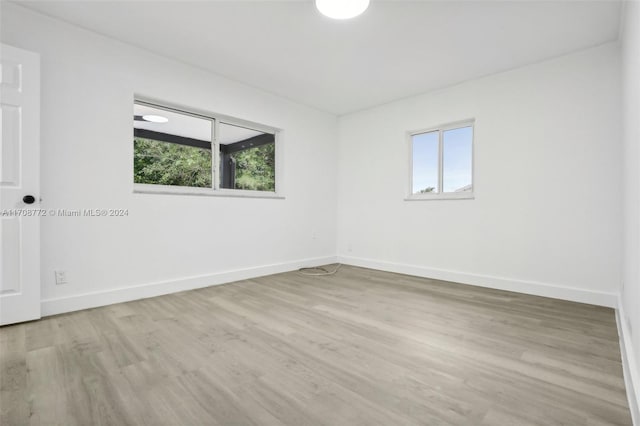 unfurnished room featuring a healthy amount of sunlight and light hardwood / wood-style floors