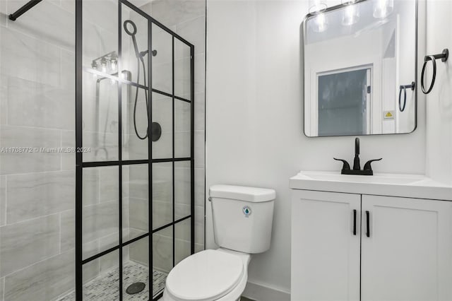 bathroom featuring toilet, vanity, and tiled shower