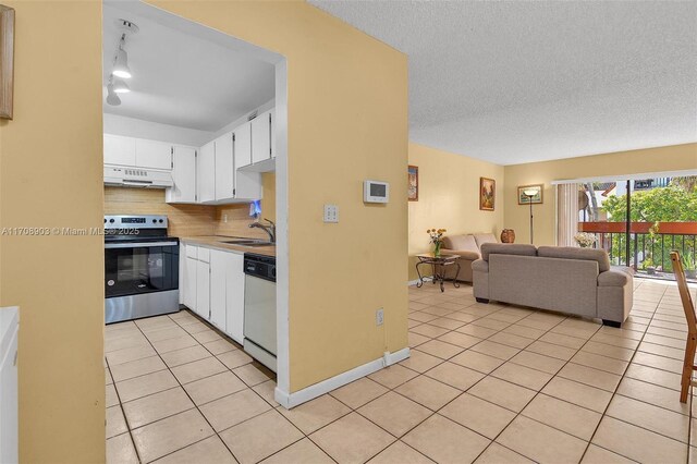 kitchen featuring light tile patterned floors, stainless steel range oven, white dishwasher, extractor fan, and white cabinets