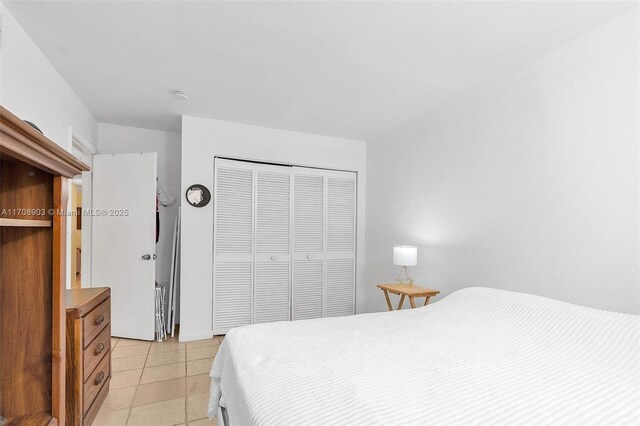 bedroom with light tile patterned floors and a closet