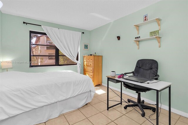 tiled bedroom featuring a textured ceiling