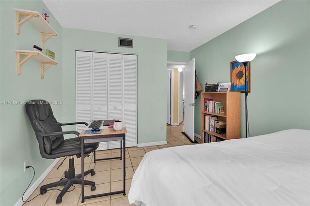 tiled bedroom featuring a textured ceiling and a closet