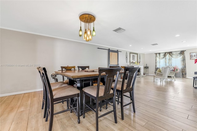 dining room with crown molding, light wood finished floors, visible vents, an inviting chandelier, and baseboards