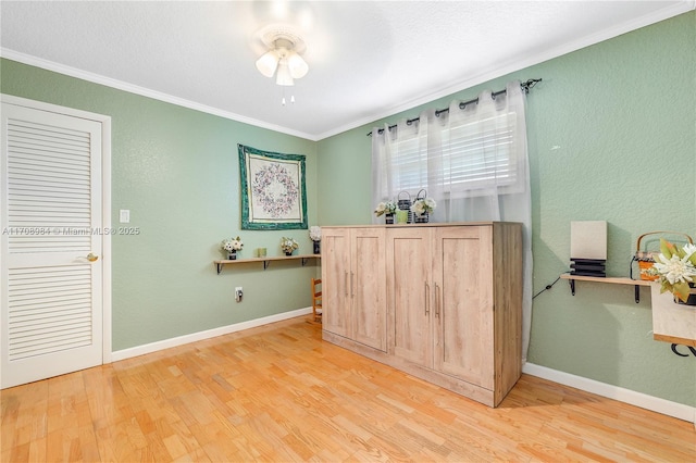 office space with baseboards, wood finished floors, and crown molding