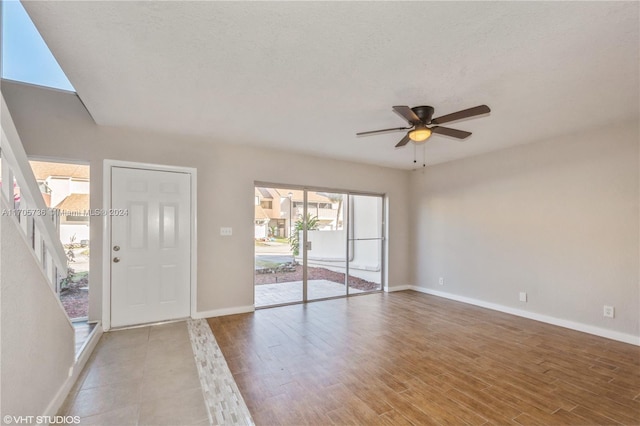 foyer featuring a wealth of natural light, ceiling fan, light hardwood / wood-style floors, and a textured ceiling