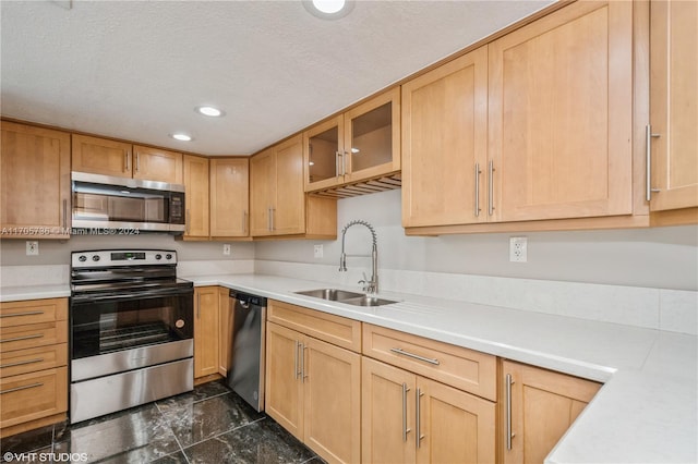 kitchen featuring light brown cabinetry, sink, a textured ceiling, and appliances with stainless steel finishes